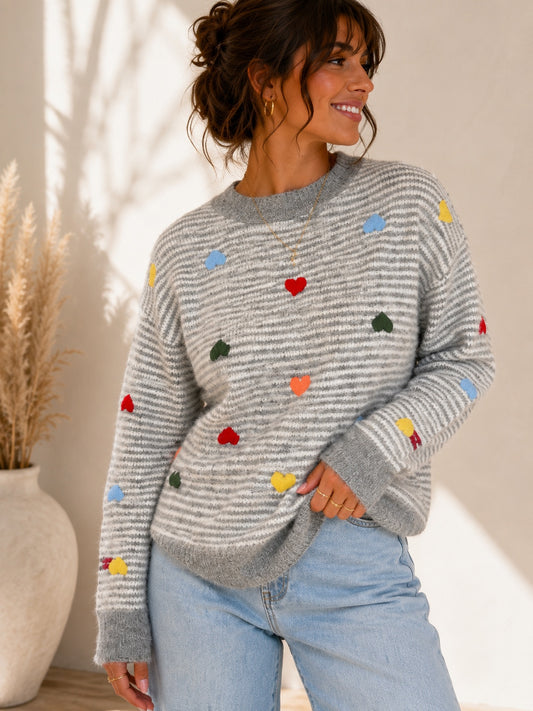 Pull Alexia col rond gris rayé avec motifs cœurs colorés porté de face